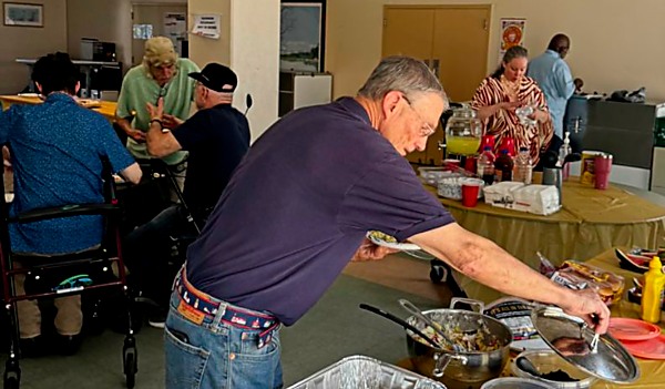 man serves self food from table