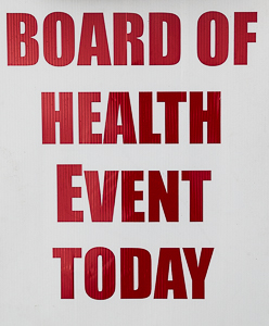 White sign with red letters, "Board of Health Event Today."