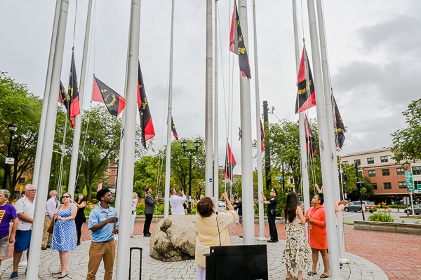 Doreen Wade and others each raise a flag.