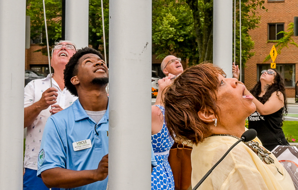 Doreen Wade and others look at flags that are atop the flagpoles.