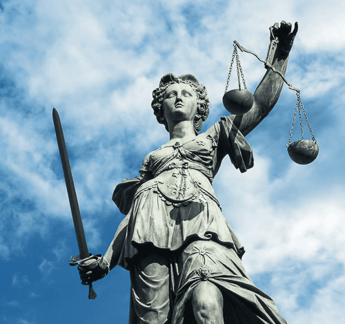Statue of justice with raised sword, scales