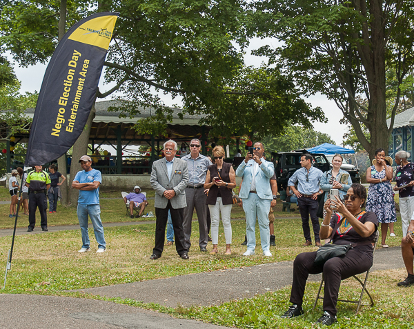 Political leaders observe the presentations and wait their turns to participate.