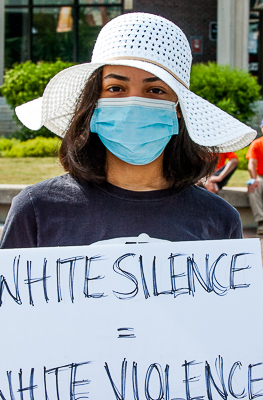 Young woman in white hat holds poster